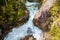 Powerful stream of mountain river running down the valley among alpine