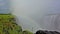 Powerful streams of Victoria Falls crash into the gorge. A rainbow appeared in the thick fog of water.