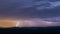 Powerful thunderstorm over hills at night