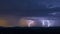 Powerful thunderstorm over hills at night