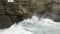 Powerful waves hitting rocky cliffs and falling to produce froth and splashes