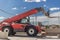 Powerful wheel forklift with telescopic mast at the construction site of a modern residential area. Construction equipment for