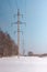 Powerlines against the clear blue sky. Several trees nearby. Winter in the city