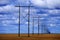 Powerlines in Field with Blue Sky and Clouds