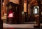 Poznan, Poland -  Confessional lit up in red, priest inside, baroque interior of the parish church `Poznan Fara`. Detai