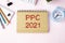 PPC ,Pay Per Click, is an acronym written on white paper on an office desk with a calculator, markers,