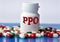 PPO - medical acronym on a white jar against the background of randomly scattered tablets
