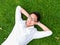 Ppretty young man in white shirt relaxing on a grass