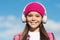 Pprotect your childs ears. Happy girl wear ear phones on sunny blue sky. Little kid listen to music in headphones. Ear