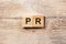 Pr word written on wood block. public relation text on table, concept