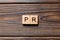 Pr word written on wood block. public relation text on table, concept