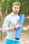 Practice yoga in park. Athlete always stretching after workout. Sportsman carries fitness mat for outdoor training