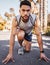 Practising for the perfect start. Full length shot of a handsome young man crouched in a start position before running