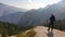 Pragser Wildsee - A man with a big hiking backpack standing at the edge of a mountain and admiring the panoramic view in front