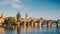 Prague Castle and the Charles Bridge at sunset in Prague, Czech Republic, Vltava river in foreground