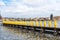 PRAGUE, CZECH - MARCH 11, 2016: Yellow Penguine Statues by the River Vltave in Prague, Czech. Charles Bridge in Background