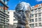 Prague, Czech Republic - April, 2018: Rotating statue of Franz Kafka head in Prague, Czech Republic against blue sky