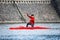 Prague, Czech republic - March 12, 2021. Young man in red shirt sailing on red single canoe in canoe sprint in sunset