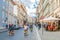 Prague, Czech Republic, May 13, 2019: people tourists are riding bicycles bikes on cobblestone street