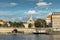 Prague,Czech Republic-September 3,2020. Postcard view of Rasin Embankment and Emauzy Monastery.Riverfront buildings,boats,peole