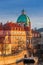 Prague, Czech Republic - The world famous St. Francis of Assisi Church dome and traditional red rooftops with beautiful golden sun