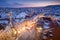 Prague Old Town in snow during late sunset with yellow lights and blue sky