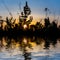 Prairie grass silhouette reflected in a calm water in a light of evening sun