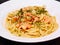 Prawn linguine pasta with basil served on a white dish