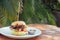 Prawns burger and french fry on table tropical sea ,palms tree and beach background