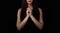 Pray, female hands on dark background.