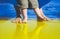 Pray for Ukraine concept background. Baby`s first steps barefoot in yellow and blue colors of flag of Ukraine as symbol of peace