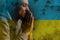 Pray for Ukraine. man prayer for peace, national flag