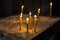 Prayer burning candles in a church on a dark background. Religious concept