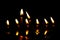 Prayer candles burning in silent darkness of temple, reflected in water