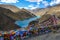 Prayer flags span along the side of a scenic road overlooking Manak Dam Lake