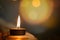 Prayer and hope concept.Candle flame light at night with abstract circular bokeh background