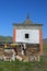 Prayer wheel building and pile of stone sheets with mantras on Tibetan Plateau