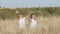 Praying concept. A man and a woman in white clothes stand in grass stretching their arms up