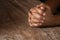 Praying hand holding together on vintage grunge wooden table selective focus