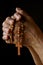 Praying hands of an old Indian Catholic woman with wooden rosary