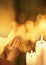 Praying person on shiny background with burning candles