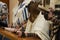 A praying young man with a tefillin on his arm and head, holding a bible book, while reading a pray at a Jewish ritual