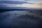 Pre-dawn foggy landscape. The river and meadow are covered with fog until sunrise