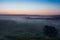 The pre-dawn haze over the rural landscape with a power line A m