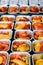 Pre-portioned Gourmet Roasted Bell Peppers in Trays. Close-up view of vibrant roasted bell peppers portioned in aluminum