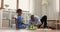 Pre-teen daughter and dad play together wooden cubes and railroad