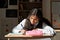 Pre-teen diligent schoolgirl making notes in copybook or writing down essay