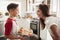 Pre-teen Hispanic boy presenting the cakes he has baked to his proud mother, close up