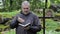 Preacher with Bible and rosary at outdoors church near cross