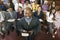 Preacher Holding Bible With Congregation Sitting In Church